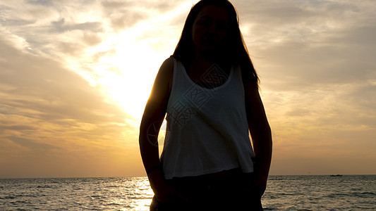 在海滩上欣赏日落的年轻美人图片