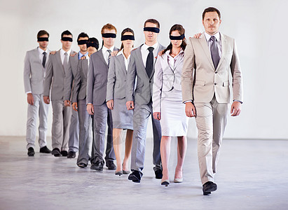 对管理隐含信心 一群蒙着眼睛的商界人士跟着他们的经理走图片