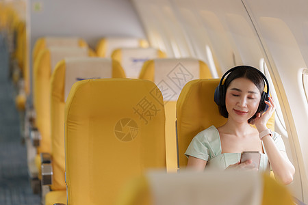 飞机WIFI乘坐飞机飞行时使用智能手机与wifi互联网连通的年轻女性亚洲裔女士空气运输地平线航空公司技术速度蓝色翅膀商业太阳背景