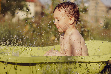 可爱的小男孩在花园里的户外浴缸里洗澡 快乐的孩子在泼水 玩水 玩得很开心 夏季和娱乐 在炎热的夏季保持凉爽 在后院玩水婴儿孩子们图片