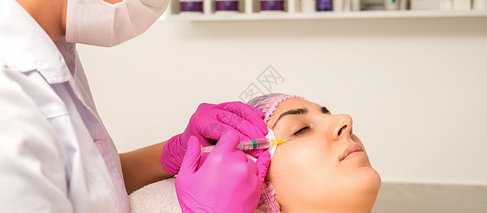 年轻白人女子在美容院里 接受青春的面部注射 眼睛上涂着血压酸皱纹美容病人诊所治疗手术皮肤女性女孩横幅图片