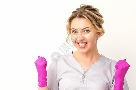 穿着粉红色手套的caucasian女医生快乐地庆祝白种背景并举起拳头成就女士成功工人优胜者成人拍卖微笑女孩喜悦图片