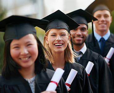 让新的冒险开始 一群大学毕业生站在帽子和礼服上 持有他们的毕业证书 (笑声)图片