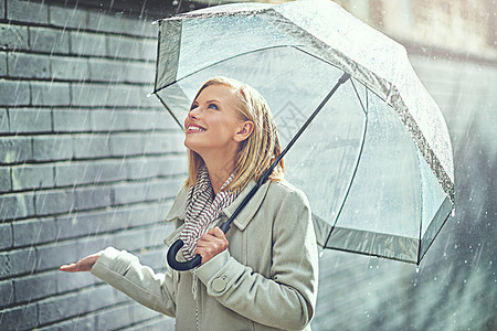 下雨的快乐 一个迷人的年轻女子在雨中行走图片