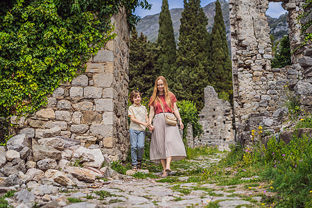 妈妈和儿子的游客穿过黑山的巴尔老城 快乐的游客走在山上 巴尔 黑山 巴尔干半岛的郊区 美丽的自然风光访问女士旅行者堡垒废墟建筑学图片