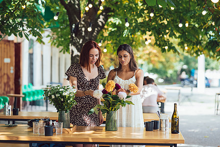 两个年轻女性 组成了一个美丽的节日花束咖啡柜台市场假期植物群命令花艺商务花店女孩们图片