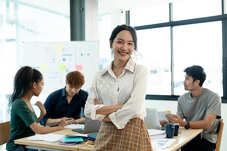 年轻迷人的亚洲女人 在会议室她的团队面前 自信地站在办公室里 满怀信心图片