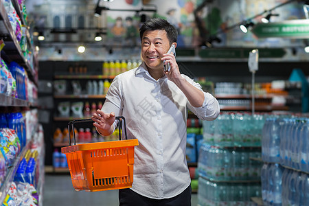 韩国超市一名亚洲商务人士在超市走来走去 并配有产品篮子 电话交谈背景