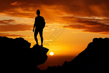 在非洲的冒险之旅中 日落 远足和一个人在山顶的轮廓 夏日傍晚 在大自然中徒步旅行时 自由 橙色的天空和站在悬崖上的人图片