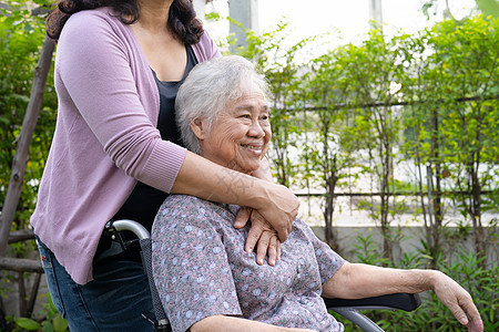 照顾者女儿帮助亚洲老人或老年老年妇女在公园坐电动轮椅 (女)图片