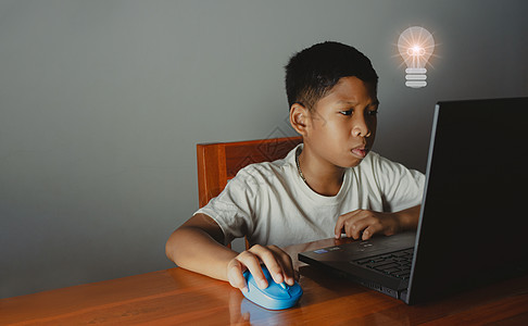 特写男孩坐着盯着笔记本电脑 他的手拿着鼠标 教育理念 教育信息搜索 复制空间桌子知识教学男性学习学校孩子技术家庭作业房间图片