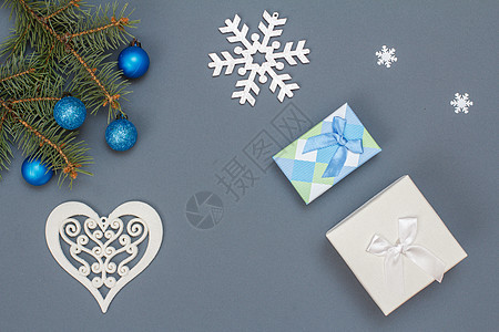 礼品盒 带玩具球的fir树枝 灰色背景的雪黑图片