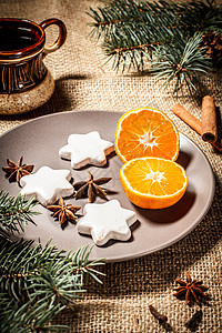星形的姜饼饼干和板盘上的橙色甜点盘子咖啡庆典麻布杯子假期勺子肉桂饼干图片