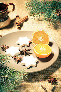 星形的姜饼饼干和板盘上的橙色锥体白色盘子食物桌子庆典咖啡甜点肉桂麻布图片