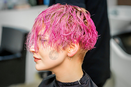 在理发店接受新的粉红色短发型 美貌美丽的年轻caucasian女人女性白色沙龙女孩皮肤成人化妆品理发师头发治疗图片