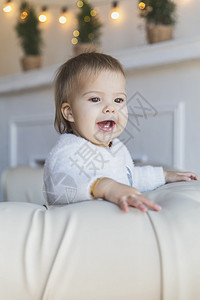 沙发上的宝宝是笑容 这样两颗牙齿就能看得见图片