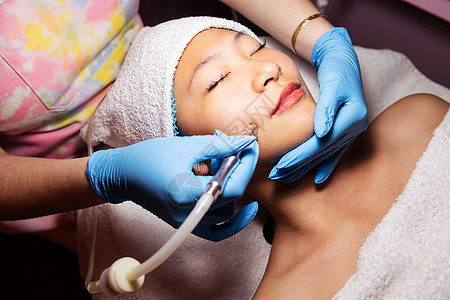 妇女接受显露的面部治疗皮肤科女孩卫生温泉沙龙护理女士诊所激光化妆品图片