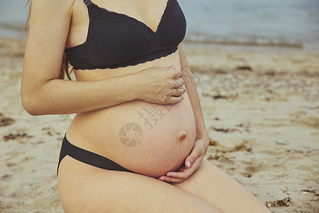 孕妇在沙滩上休息的近身图片