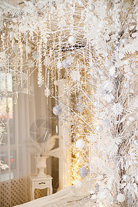 房子的内部装饰着一棵圣诞树 以迎接节日的到来 宽敞明亮的房间装饰有装饰品 新年 圣诞节装饰奢华壁炉魔法季节沙发窗户公寓卡片假期酒图片