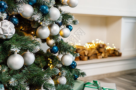 圣诞树是为圣诞节而装饰的 装饰精美的房子 有银色 白色和圣诞树和礼物 一段神奇的时光 新年玩具风格盒子丝带壁炉房间季节花环假期装图片