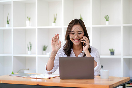 美丽的亚洲女商务人士在电话上玩得很开心 和办公室的一位顾客通过视频通话图片