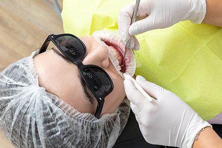 诊所内有牙科镜的病人嘴腔和牙科镜愈合工具女性镜子程序反射口服治疗乐器医院图片