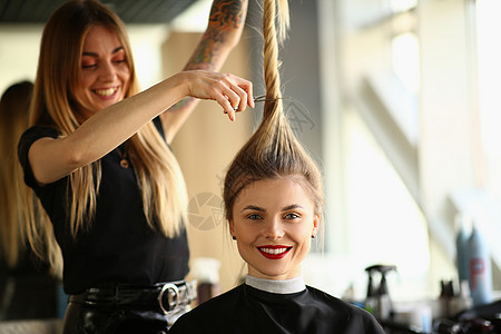 专业女性美发师造型师在沙龙剪发女性客户的头发图片