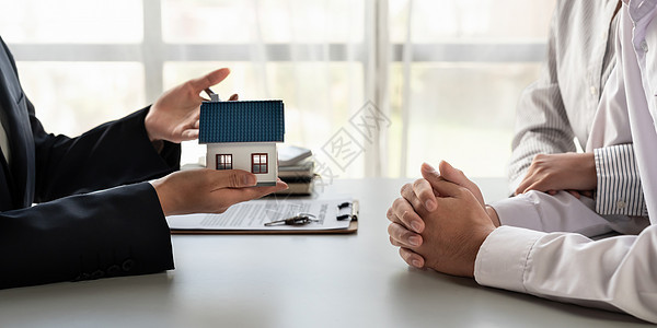 房地产经纪人向一对夫妇展示一个项目房产模型 (笑声)图片