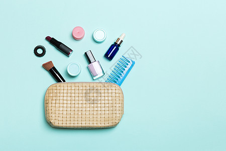 蓝色背景的化妆品袋溢出的化妆品包装和皮肤护理产品的最顶端视图 美观概念图片