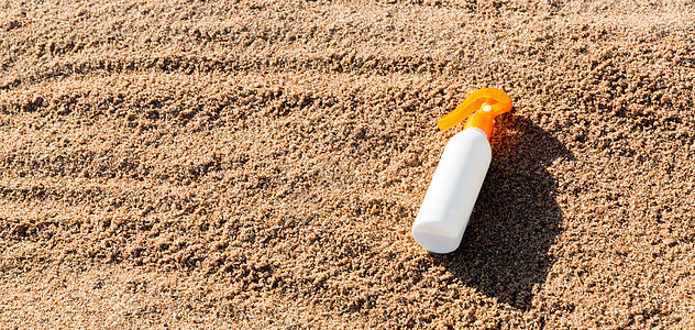 夏季假期在海滨的防晒霜夹奶油剂概念(图片