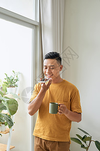 男人使用家庭窗户附近的手机的语音识别器;男子使用家门窗旁边的电话图片