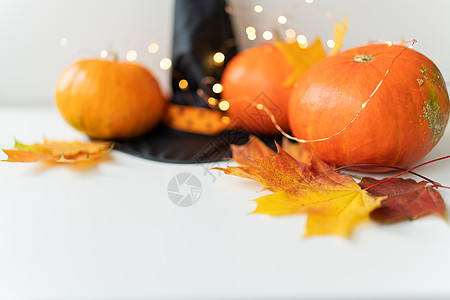 底部有南瓜边框的秋叶 黑色的帽子 美丽的秋天背景 背景上闪烁的灯光 美丽的散景橙子感恩宏观明信片蔬菜季节植物艺术桌子树叶图片