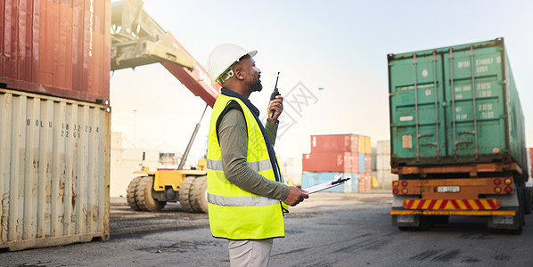在航运港口的运输和供应链行业从事库存 物流和货物交付工作的黑人 员工通过无线电通信出口集装箱以进行出口配送图片
