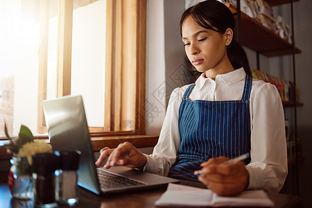 咖啡店 笔记本电脑和财务 一位女经理或小企业主管理着她咖啡馆的账簿 一位女性在她的餐厅在线工作的初创公司 企业家和管理人员图片