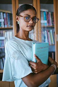 有图书馆印刷书籍的女学生从书架上拿来进行大学或大学教育和学习知识 手拿精装英文书学习或阅读的年轻女性或人图片