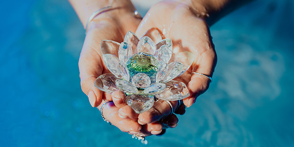 拿着易碎的莲花的妇女 清澈的水珠从水晶中滴落 宗教 昆达里尼 冥想 脉轮 精神内心世界的概念女士美丽叶子椭圆形游泳池矿物玻璃水晶图片