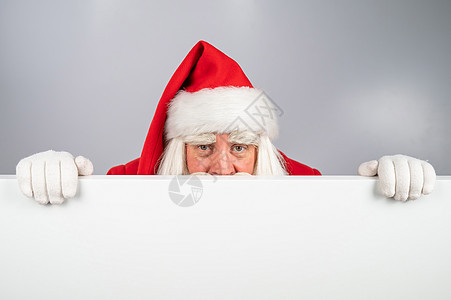 圣诞老人在白背景广告后面偷看 圣诞快乐 圣诞快乐传统销售喜悦手套祖父手势木板庆典胡须男性图片