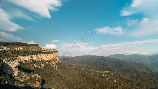 横跨蓝色白天天空的云彩在山绿色山谷 岩石和山丘上的云影 鸟瞰自然图片