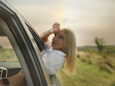 一位美丽的女孩骑着汽车快速地乘车 享受窗外的风声 工作休息和繁忙 宁静和自由引擎情况发动机姐姐友谊挫折警告帮助姿势头发图片
