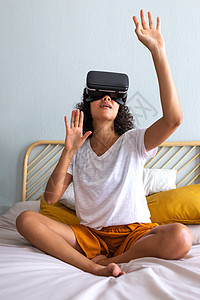 年轻多种族的拉蒂纳女青年在家中使用VR眼镜移动手触摸3D世界中的物体 复制空间图片