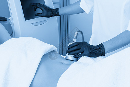 超声空化塑身治疗 女人在美容院的腿上接受抗脂肪和抗脂肪治疗女性按摩女孩空化程序沙龙女士组织身体蓝色图片
