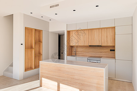 带橱柜设计内饰的轻型模块化厨房 采用白色和浅棕色制成 阳光照亮了新的现代厨房用具 带大理石台面和蜂蜜橡木家具的白色厨房单元桌子公图片