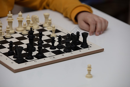 坐在一张桌子下棋 孩子全神贯注于游戏 思考着下一步该往哪里走 早期发展 儿童家庭教育游戏智力学习爱好数字思维木板闲暇学校战略童年图片