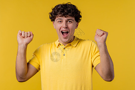 卷毛男人显示胜利是是的胜利姿态 他取得了结果 目标 黄色背景的家伙高兴 快乐 惊讶兴奋快乐的女士 头奖概念图片