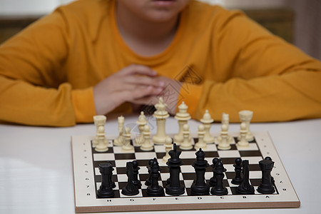 坐在一张桌子下棋 孩子全神贯注于游戏 思考着下一步该往哪里走 早期发展 儿童家庭教育游戏智力学校逻辑教育思维专注学习挑战乐趣数字图片