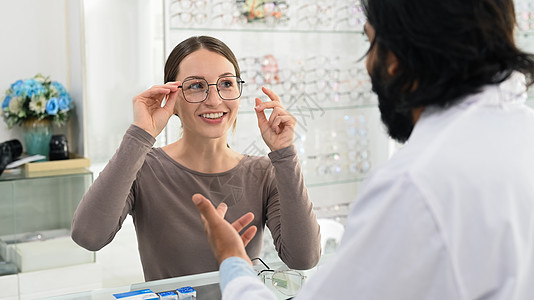 与专业眼科医生一起选择眼镜眼镜的有笑脸的caucasian女性 眼睛健康检查和眼科学概念图片