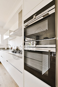 厨房 有白色柜子和不锈钢炉房子财产烹饪桌子房间木头奢华公寓风格冰箱图片