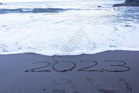 写在黑沙沙滩上的2023年符号海洋海滩幸福假期海浪数字旅行异国新年情调背景图片