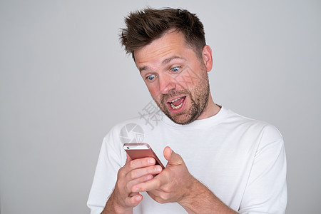 男人看着智能手机屏幕 微笑与朋友聊天时笑得愉快的笑容图片