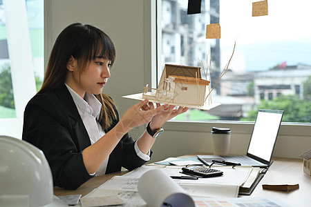 从事建筑计划设计和在办公室检查建筑计划的女建筑师人士桌子开发商装修建筑学工程草图电脑商务项目图片